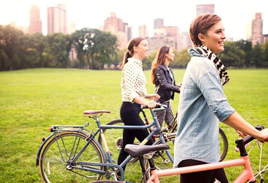 mujeres al aire libre con bicicleta en mano